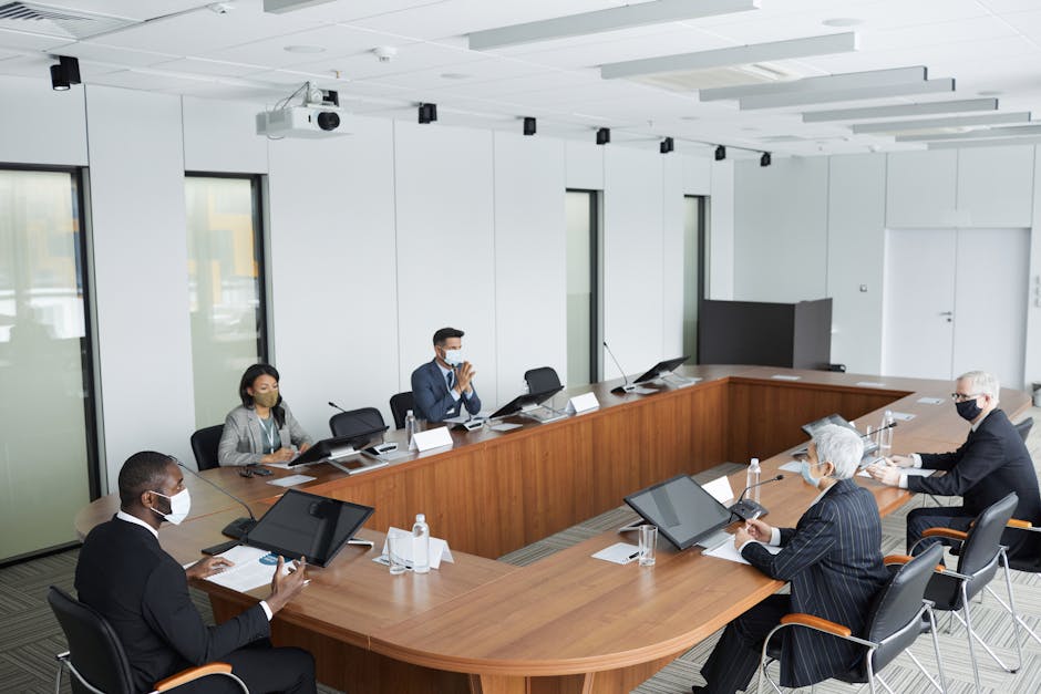 Business professionals wearing masks attending a conference meeting in a modern setting